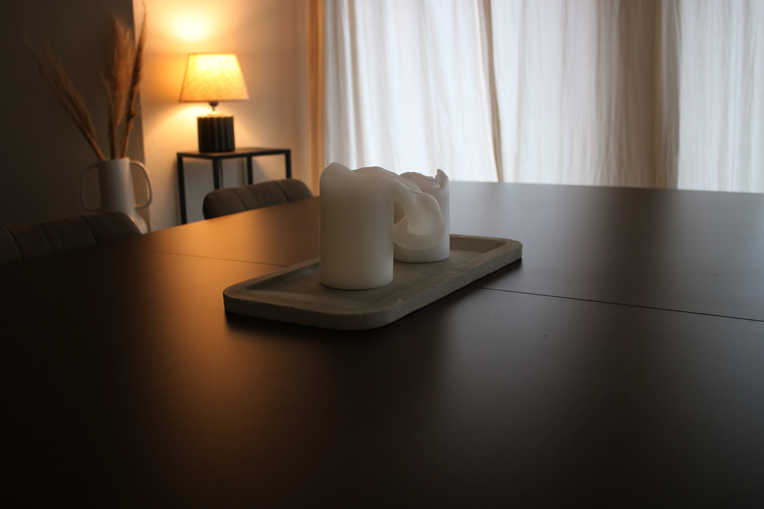 Dekoratives Beton Tablett auf dem Esstisch mit Kerzen verziert